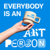 Hand holding a mug with 'ART PERSON' text against a blue background with motivational quote: Everybody is an art person.