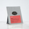Standard size grey loose leaf pouch with a deep pink Kissmet label against a marble background.