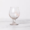 Empty snifter glass branded with Smith logo on marble table.
