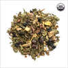 Circular pile of cocao nibs, ginger, peppermint leaves and nutmeg. 