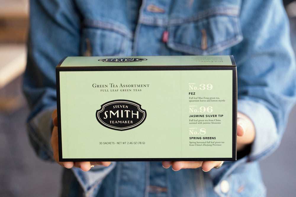 Person holding green box with black trim.