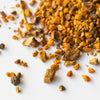 Pile of loose dried turmeric, black pepper and sarsaparilla on marble background.