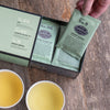 Green box with black trim on wooden table.