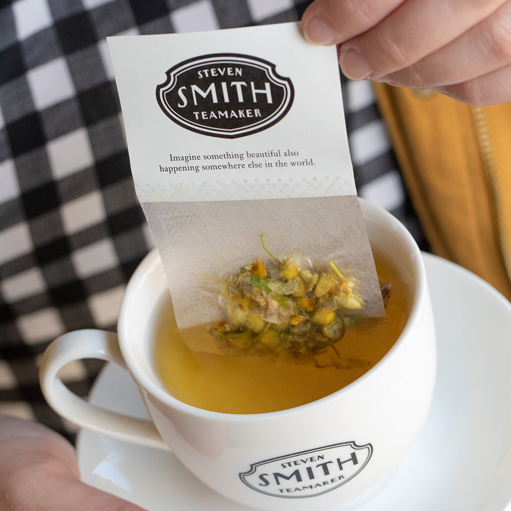 White paper filter with black Smith logo shield filled with chamomile petals.
