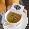 White paper filter with black Smith logo shield filled with chamomile petals.