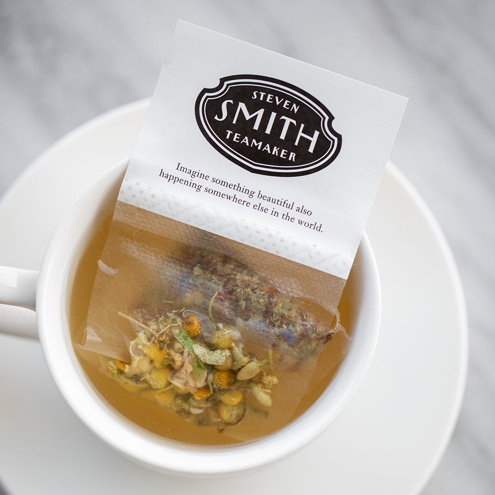White paper filter with black Smith logo shield filled with chamomile petals.