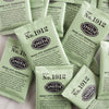 A pile of overwrapped sachets of Rose City Genmaicha green tea.