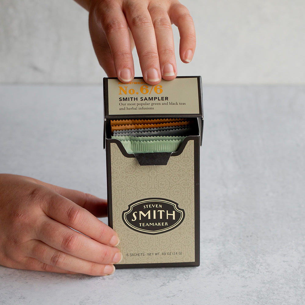 Hand closing dark silver box with black trim.